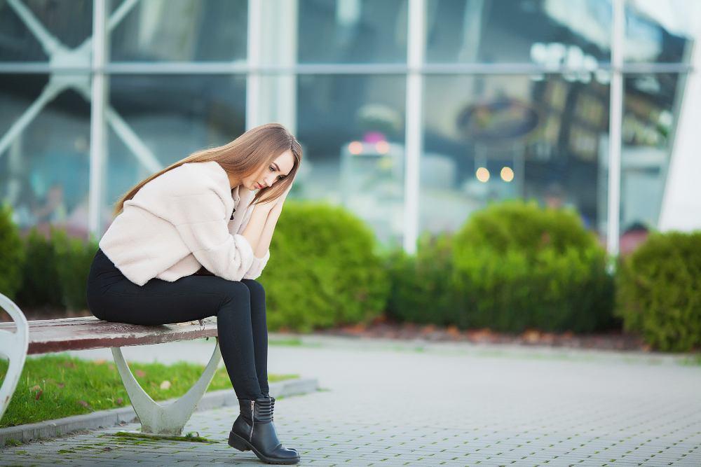 Woman stressed from work while sitting outdoors